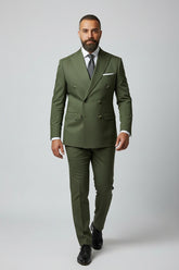 Man wearing olive double-breasted suit with peak lapels, tailored fit for formal occasions.